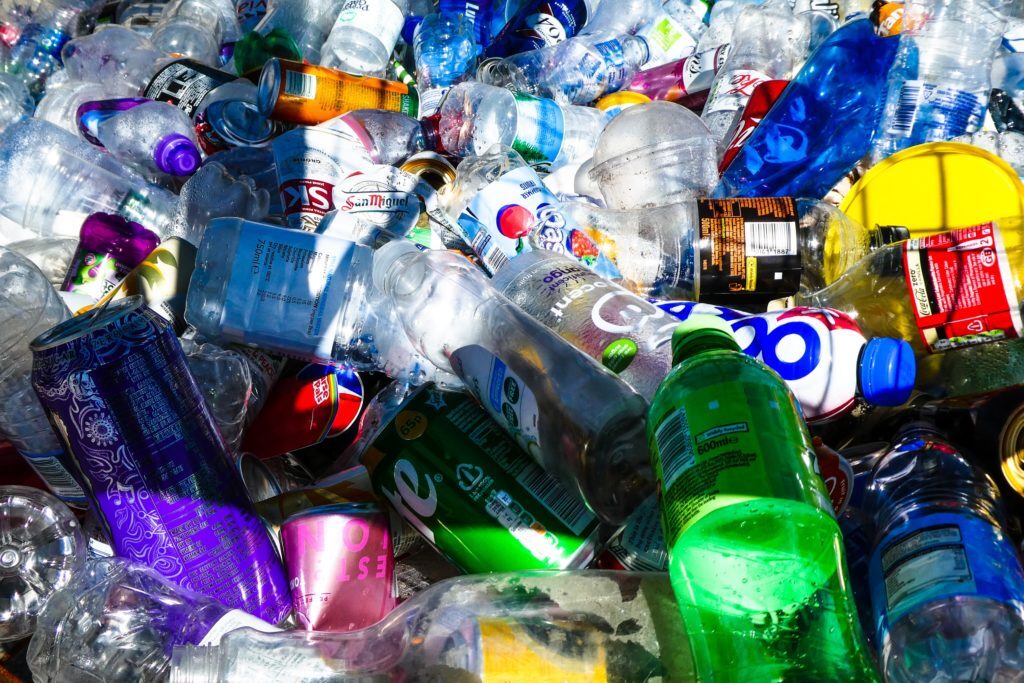 Different types of plastic bottles and cans from various producers.