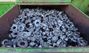 Metal waste in green garabge contaier.