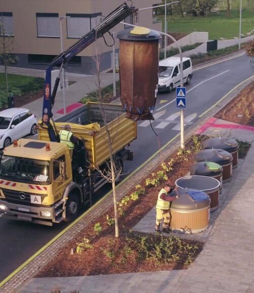 Waste collection truck picking up the underground bins with an hydraulic arm.