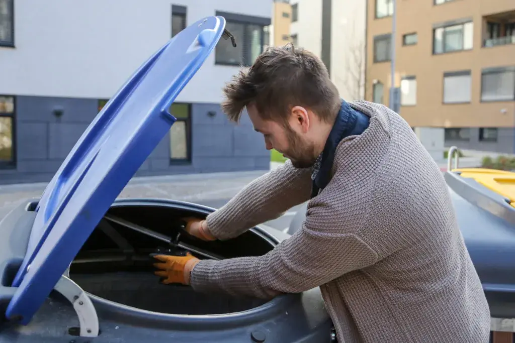 A technician is installing the smart sensor in the semi-underground bin. 