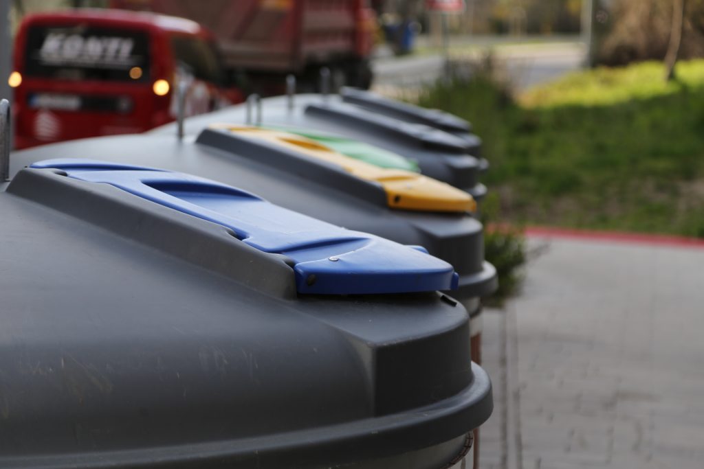 Semi-underground bin for different types of waste at garbage stand.