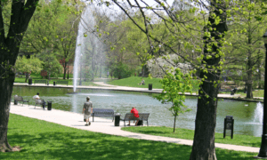 City park with a small lake and people walking.