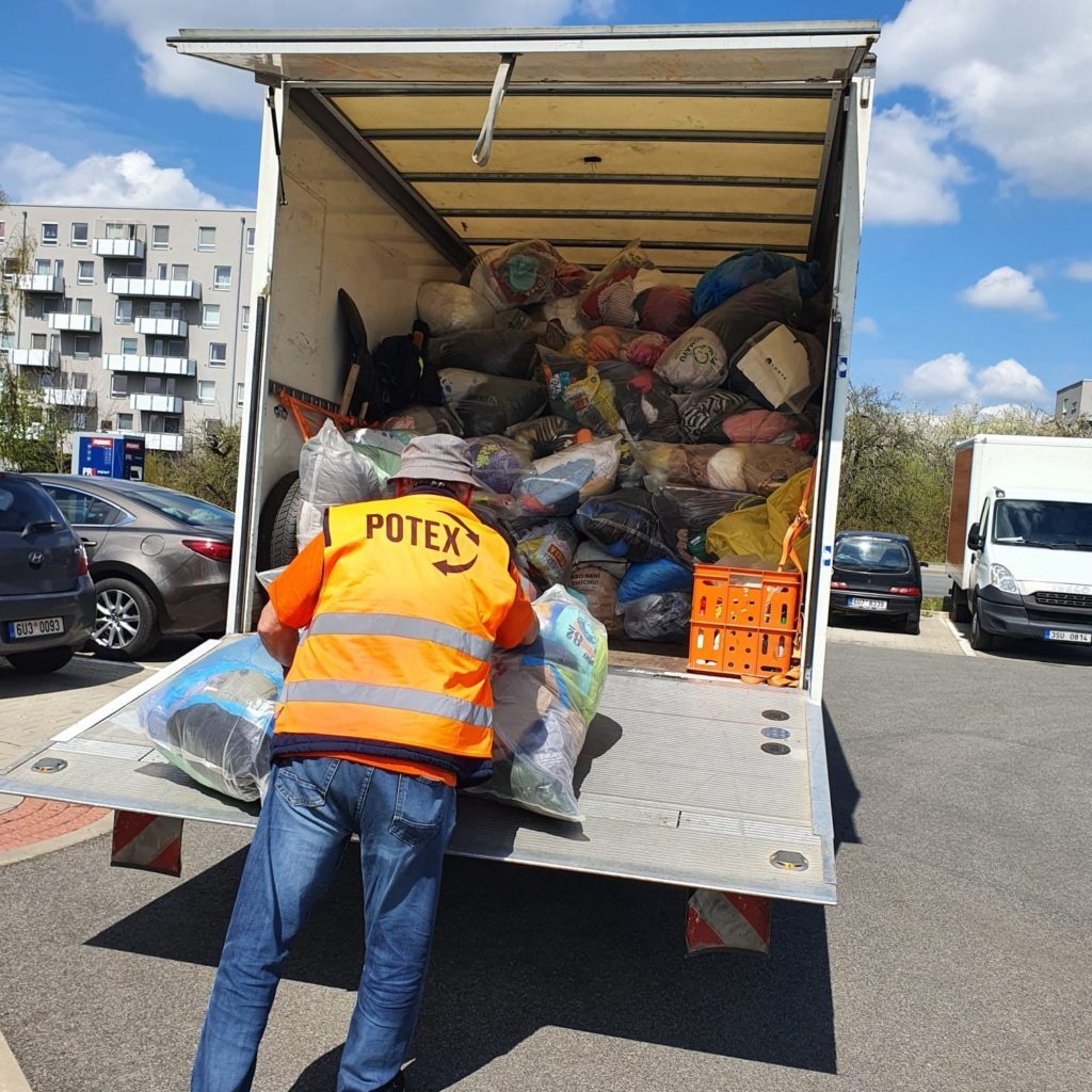 A worker of Potex taking garbage bags full of used clothing from the truck into their warehouse. 