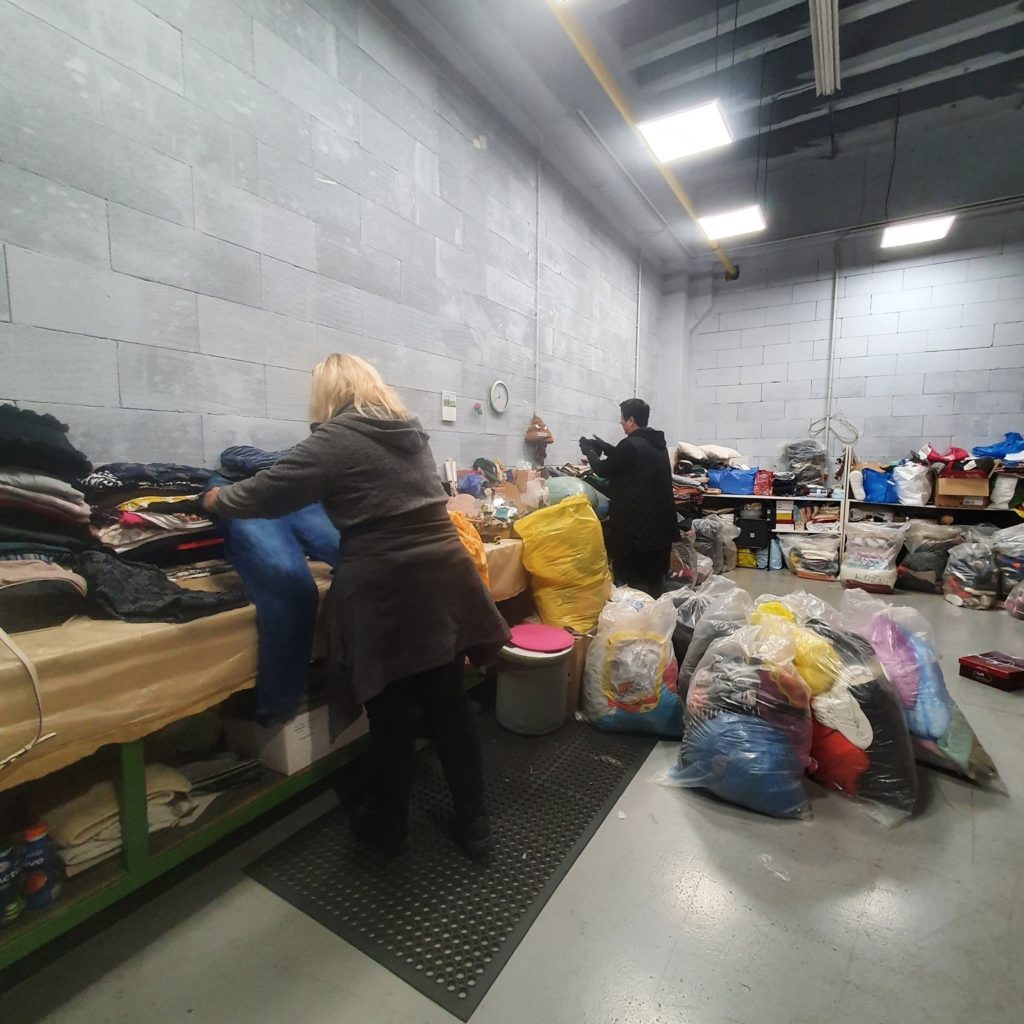 Ladies are sorting the collected used textile in a sorting facility. 