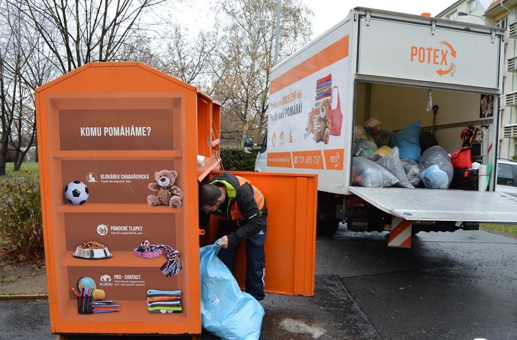 A Potex employee empties a container full of bags of old clothes.