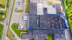 Drone view of the facility and production hall with parking and roads nearby.