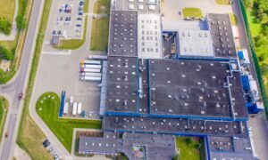 Drone view of the facility and production hall with parking and roads nearby.