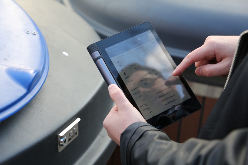 A man holding a tablet in his hand and setting the app. 