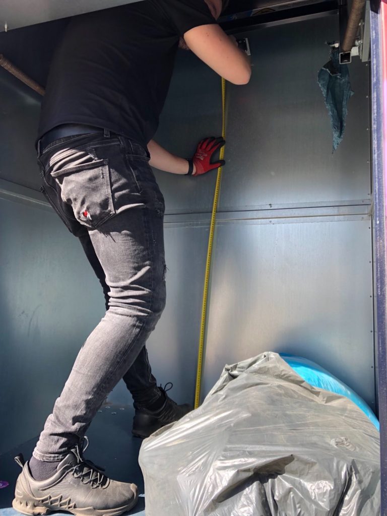 A technician deploying a smart sensor into a textile waste container.