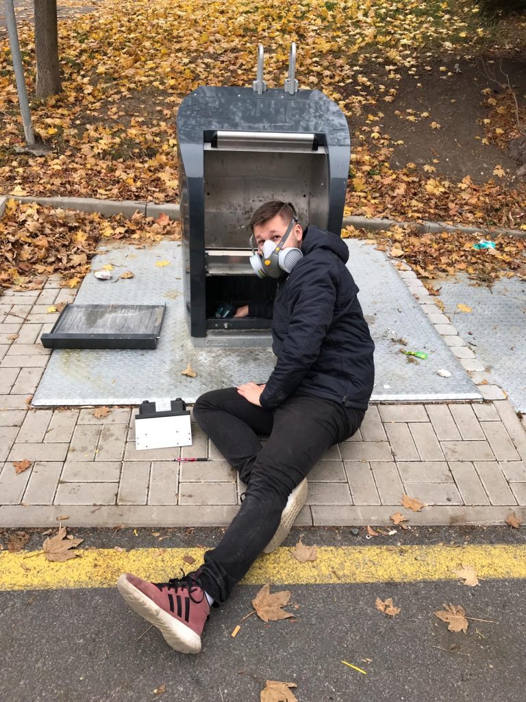 A technician installing sensor into underground bin in Prague.